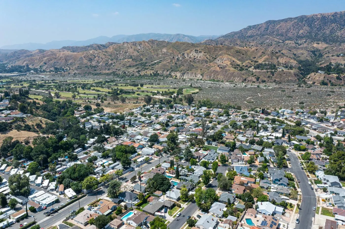 Aerial view of a Sunland neighborhood with the foothills rising behind it